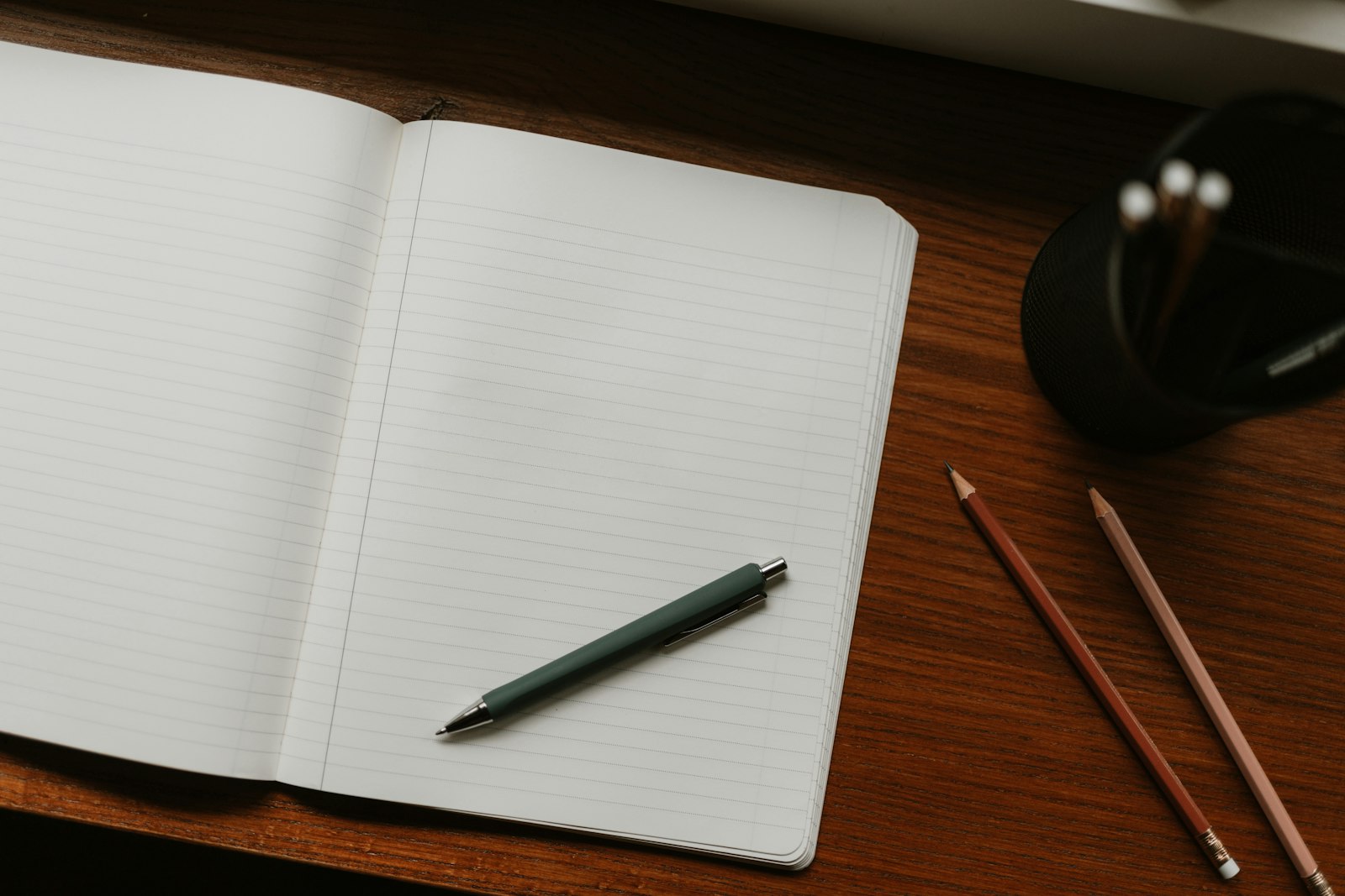 Carnet ouvert et stylo posés sur un bureau en bois